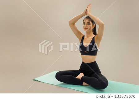 Woman practicing yoga in lotus pose on mat, yoga meditation and stretching fitness routine for wellness, balance and healthy lifestyle, yoga practice and mindful exercise in calm studio space. Woman practicing yoga in lotus pose on mat, yoga meditation and stretching fitness routine for wellness, balance and healthy lifestyle, yoga practice and mindful exercise in calm studio space. 133575670