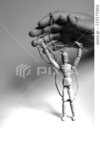 Man's hand pulling strings of wooden puppet. Concept of emotional manipulation,dictatorship and control Man's hand pulling strings of wooden puppet. Concept of emotional manipulation,dictatorship and control 133575860