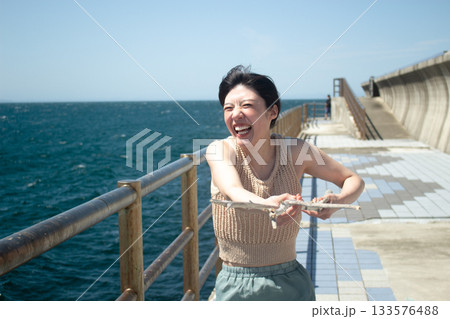 海辺でリラックスする若い女性のポートレート 133576488