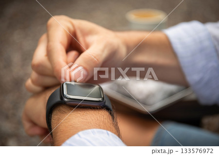 Checking the smartwatch during a freelance work session in Bali 133576972