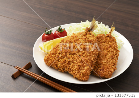 白い丸皿に盛りつけたアジフライ 133577315