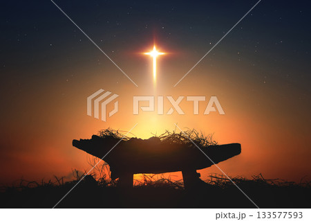 A large star in the shape of a cross illuminates the Saint Jesus in a manger, a Christmas background symbolizing the birth of baby Jesus and his death on the cross. 133577593