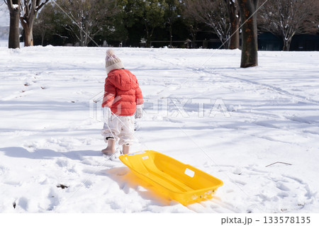 ソリを引く雪の公園で遊ぶ女の子 133578135