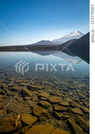 透き通る本栖湖の湖面と遠望の富士山が映える秋景色（山梨県身延町） 133578863