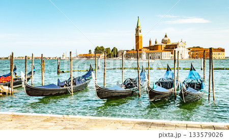 Moored gondolas at St. Mark Square with Church of San Giorgio Maggiore on background. Venice, Italy 133579026