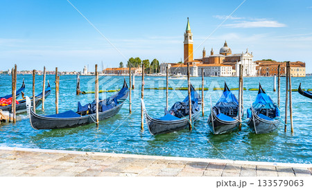 Moored gondolas at St. Mark Square with Church of San Giorgio Maggiore on background. Venice, Italy 133579063