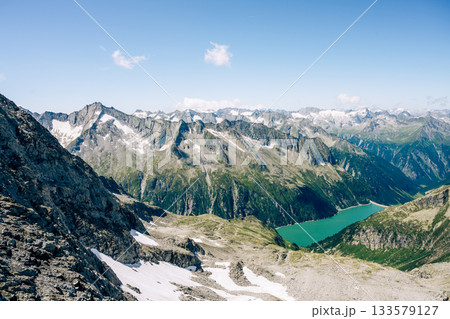Summer alpine scenery with turquoise blue water reservoir. Zillertal Alps, Austria 133579127