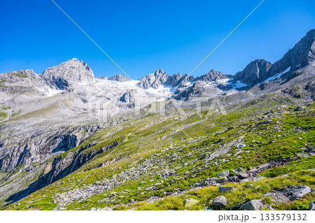 Summer alpine peaks with melting glacier on sunny day. Reichenspitze ridge in Zillertal Alps, Austria Summer alpine peaks with melting glacier on sunny day. Reichenspitze ridge in Zillertal Alps, Austria 133579132