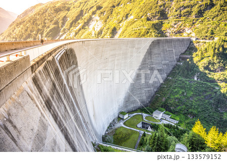 Huge concrete apline dam on sunny summer day. Zillergrundl Speicher, Zillertal Alps, Austria Huge concrete apline dam on sunny summer day. Zillergrundl Speicher, Zillertal Alps, Austria 133579152