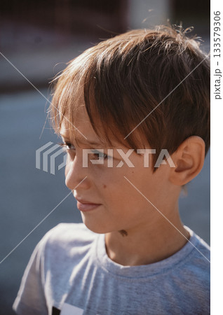 Thoughtful Child Looking into Distance Outdoors 133579306