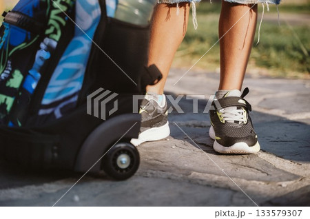 Child with Backpack and Sneakers on Stone Pathway Child with Backpack and Sneakers on Stone Pathway 133579307