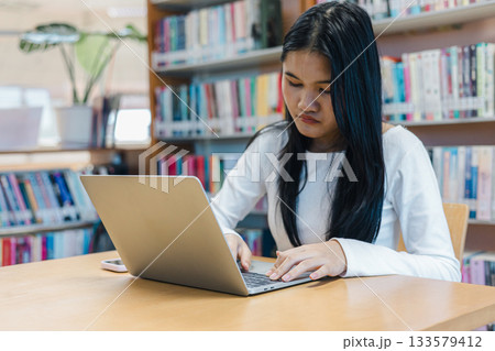 Female Student Studying with Laptop in Library for Learning and Education Concept Female Student Studying with Laptop in Library for Learning and Education Concept 133579412