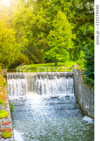 Small double waterfall on the forest stream. Gaden stone sluice in tranquil forest mood. 133579480