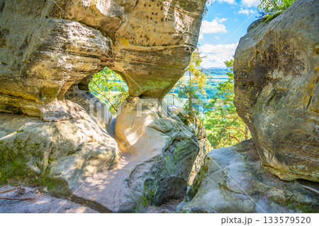 Discover the unique sandstone formations of Prihrazy Rocks in Bohemian Paradise, Czechia, showcasing natural arches and scenic views in a tranquil outdoor setting. 133579520