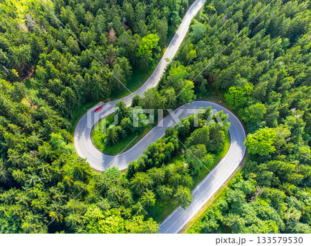 Asphalt road serpentine in the forest. Aerial view from drone. Asphalt road serpentine in the forest. Aerial view from drone. 133579530