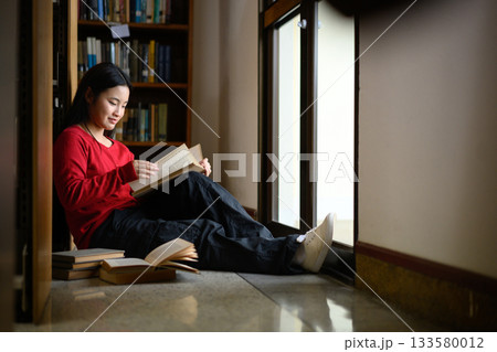 High school student girl reading book at library High school student girl reading book at library 133580012