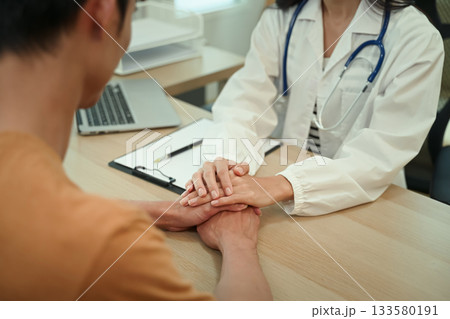 closeup empathy trust and doctor holding hands with patient , consulting support and healthcare advice 133580191