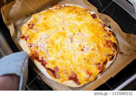 Homemade Baked Pizza with Sausage, Cheese, and Onion on Baking Tray 133580332