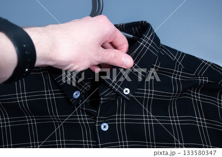 Buttoning Shirt on Black Plaid Shirt Buttoning Shirt on Black Plaid Shirt 133580347