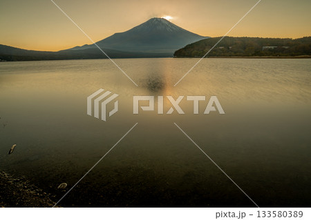 夕暮れの山中湖に映る富士山と柔らかな夕陽の風景（山梨県） 133580389