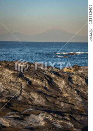 城ヶ島の荒々しい岩礁と冬の海に遠望する富士山の朝景 133580405