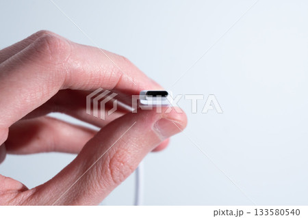 Hand Squeezing White usb Cable in Close-Up Hand Squeezing White usb Cable in Close-Up 133580540