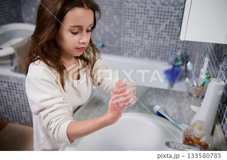 Young Girl Washing Hands With Soap In Bathroom As Part Of Daily Hygiene Routine 133580785