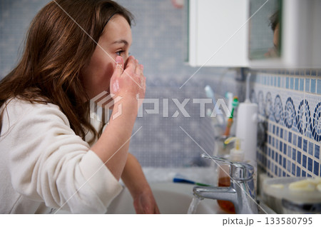Woman Washing Face At Bathroom Sink During Morning Routine, Personal Care And Self-Care 133580795