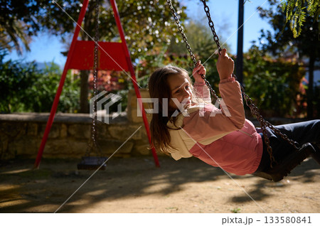 Joyful Girl On Swing In Park On Sunny Autumn Day 133580841