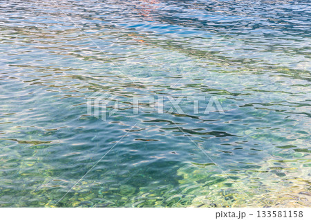 Vibrant sea  water surface with colorful reflections on soft waves 133581158