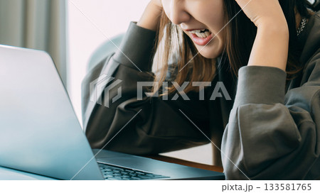 パソコンを使いながら頭を押さえて悩む女性 パソコンを使いながら頭を押さえて悩む女性 133581765