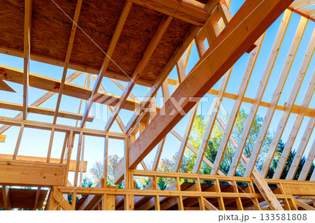 Builders are constructing new house, roof framing, wooden beams frame Builders are constructing new house, roof framing, wooden beams frame 133581808
