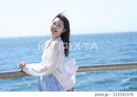 海辺に立つ笑顔の女性 133582376