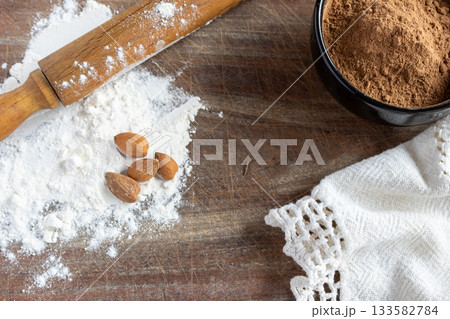 Baking still life, cocoa powder, white flour, walnuts and rolling pin on rustic wooden surface. Copy space Baking still life, cocoa powder, white flour, walnuts and rolling pin on rustic wooden surface. Copy space 133582784