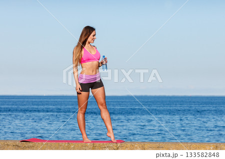 Woman drinking water after sport gym outdoor 133582848