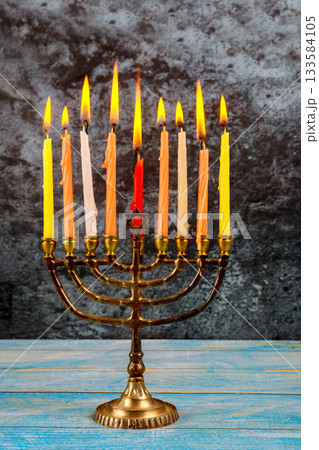 Glowing menorah with celebration candles lit on Jewish holiday symbolizing warmth of Hanukkah festivities. 133584105