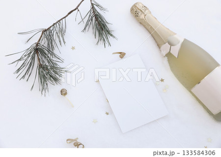 Festive winter flat lay. Champagne bottle, blank card, pine branch, golden star confetti on snowy background. Birthday celebration, New Year Party Invitation. Christmas holiday greeting mockup scene. Festive winter flat lay. Champagne bottle, blank card, pine branch, golden star confetti on snowy background. Birthday celebration, New Year Party Invitation. Christmas holiday greeting mockup scene. 133584306