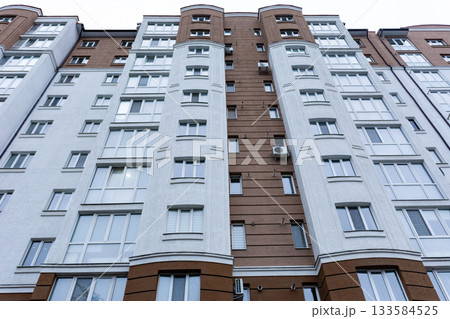 Modern urban architecture showcases a blend of textures and colors in a stylish residential building during twilight Modern urban architecture showcases a blend of textures and colors in a stylish residential building during twilight 133584525