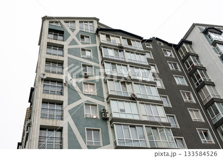 Modern apartment building with unique architectural design in an urban setting under a cloudy sky 133584526