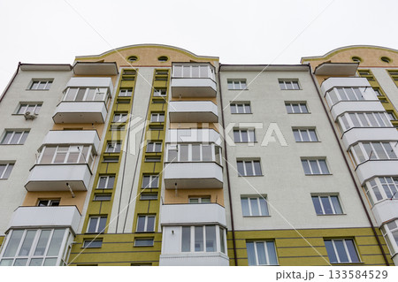 Modern apartment building showcasing distinctive architecture and clean lines in an urban setting on a cloudy day Modern apartment building showcasing distinctive architecture and clean lines in an urban setting on a cloudy day 133584529