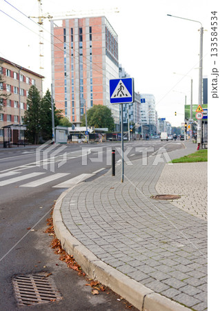 Quiet urban street in early morning with pedestrian crossing and modern buildings in the background 133584534