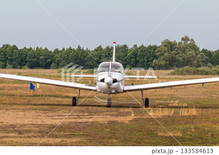 Front view of the private single-engined piston-powered aircraft taxiing at the airfield Front view of the private single-engined piston-powered aircraft taxiing at the airfield 133584613