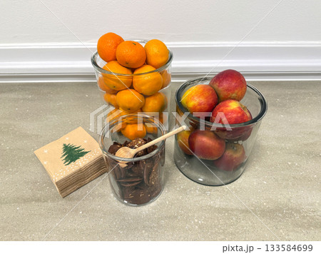 Holiday treat display with mandarins, apples, and cookies 133584699