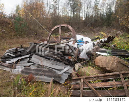 discarded objects reclaimed, valuable recovered items scattered among rubbish and debris, various usable materials like tubing and rim found concealed within waste and unwanted plant growth 133585172