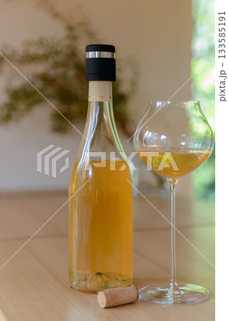 ナチュラルオレンジワインのボトルとワイングラスのクローズアップ 133585191
