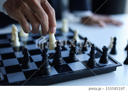 Businessman wearing suit, playing chess, game, Business strategy, leadership and management concept. 133585197