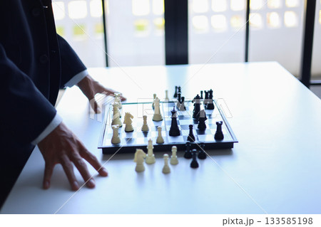 Businessman wearing suit, playing chess, game, Business strategy, leadership and management concept. 133585198