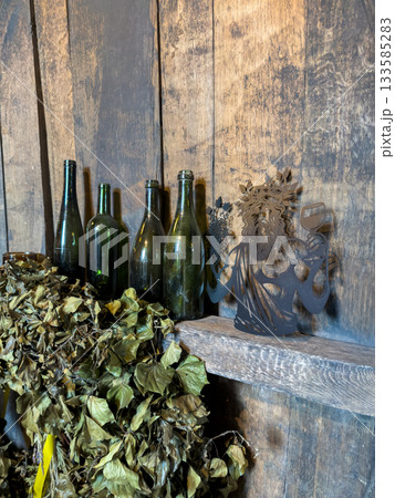 Old wine bottles and dried leaves on rustic wooden background. Old wine bottles and dried leaves on rustic wooden background. 133585283