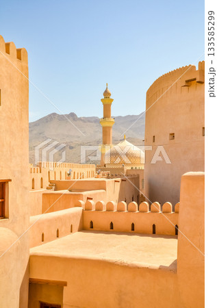 Nizwa Fort with mosque minaret, traditional architecture in Oman Nizwa Fort with mosque minaret, traditional architecture in Oman 133585299