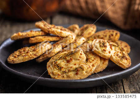 Crunchy salted crackers on plate on wooden table. 133585475